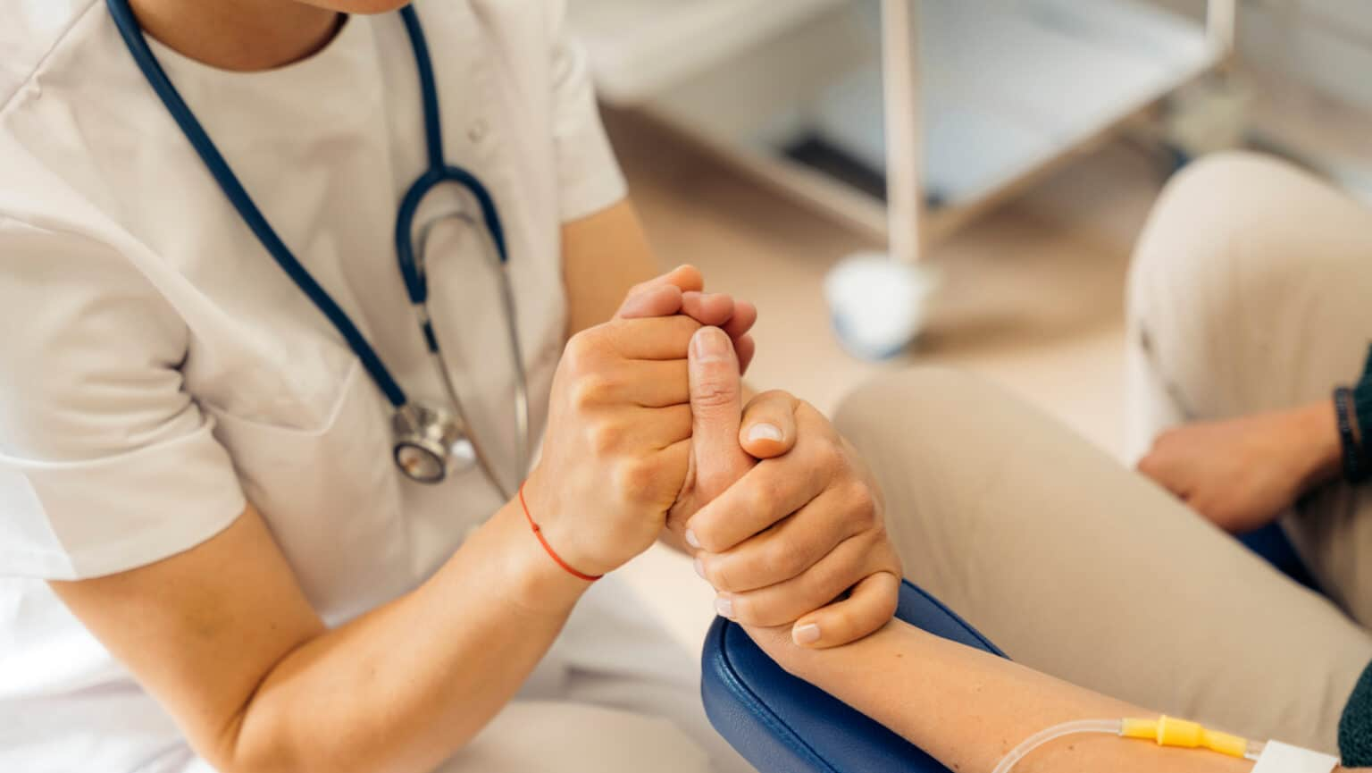healthcare provider holding a patient's hand